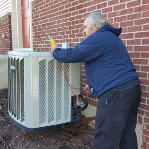 Photo of an air conditioner being diagnosed and repaired