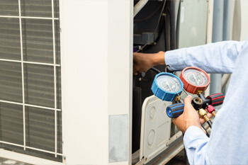 Photo of a man inspecting and repairing an ac unit