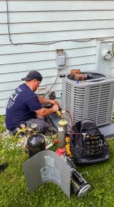Photo of Tritan Services diagnosing and repairing an air conditioning unit
